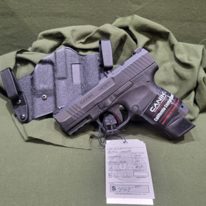 Modern semi-automatic pistol with a holster and loaded magazine displayed on a firearm sales counter at Old Town Tactical.