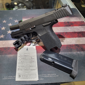 Modern semi-automatic pistol with a detachable magazine displayed on a firearm sales counter at Old Town Tactical.