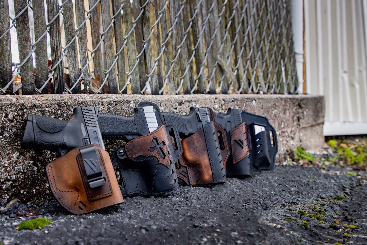 Premium leather and Kydex concealed carry holsters displayed with compatible handguns for everyday carry.
