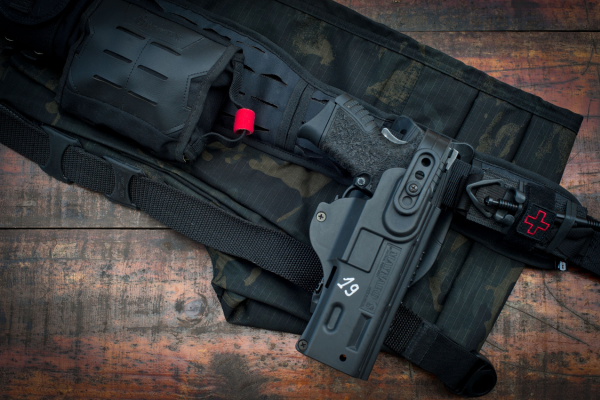 Black tactical drop leg holster securely carrying a semi-automatic handgun attached to an adjustable thigh platform for duty, training, or outdoor use.